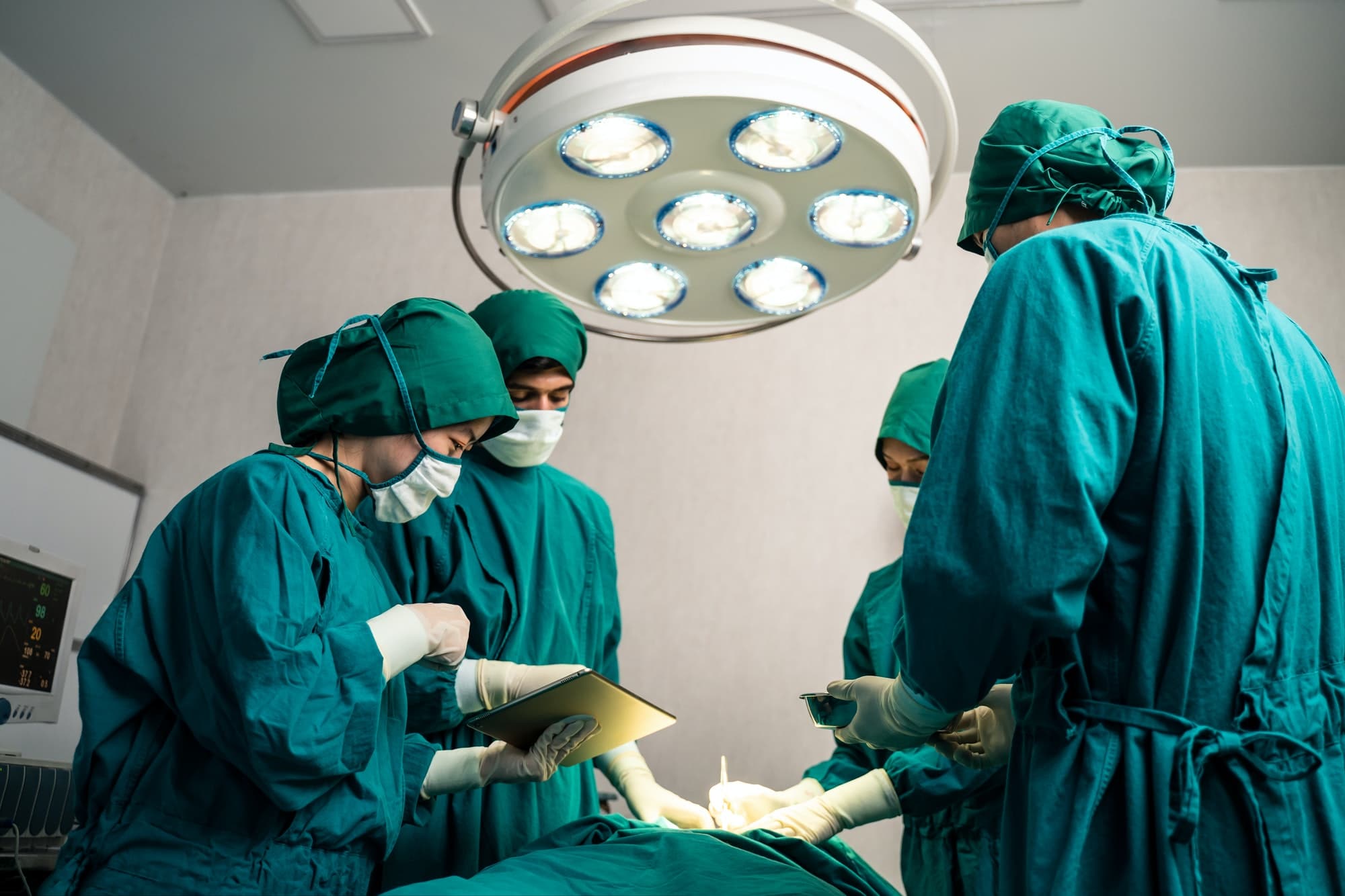 Professional medical team performing surgical operation in modern operating room.